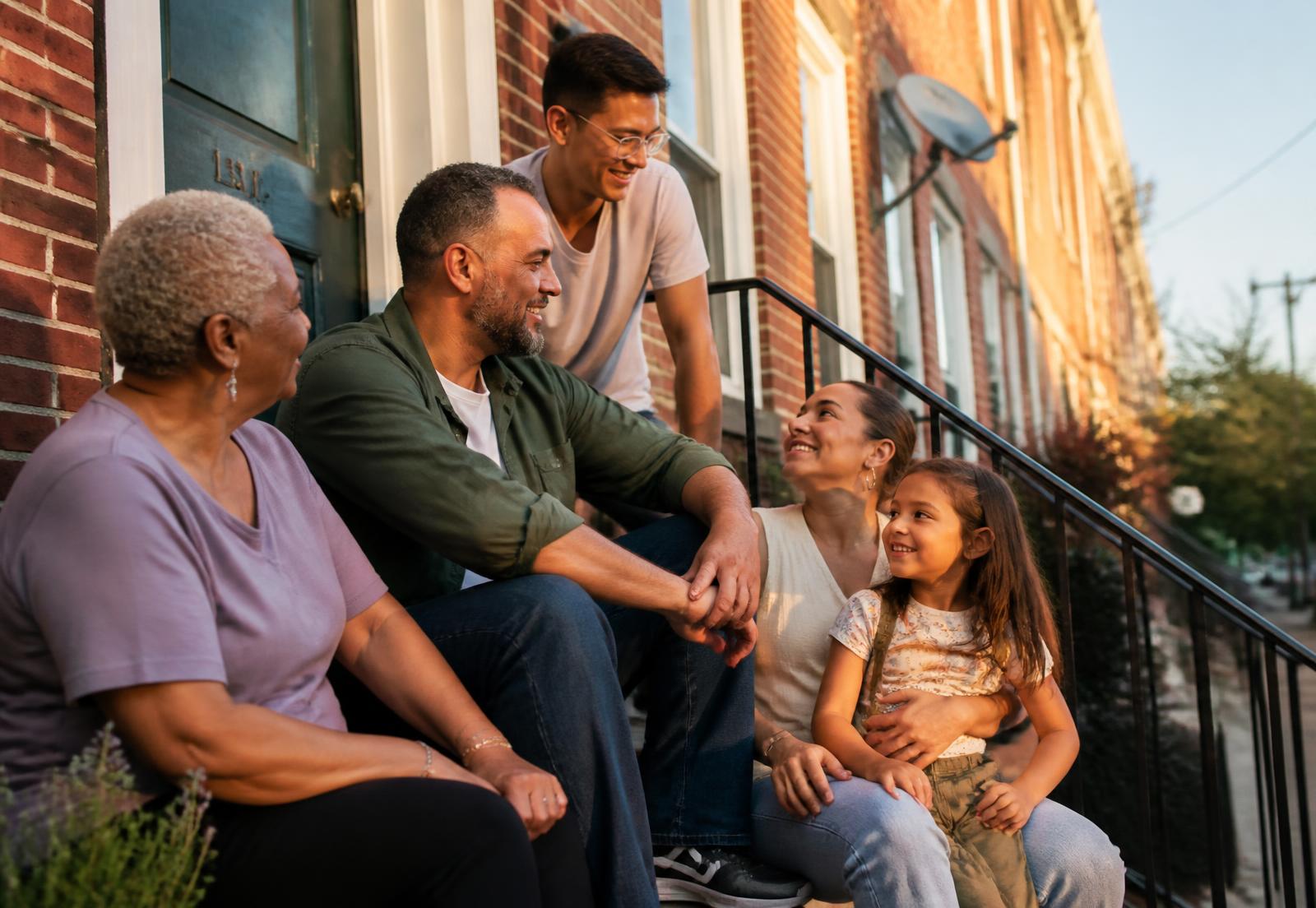 People of all ages gathered on the front steps of a New Jersey home at golden hour